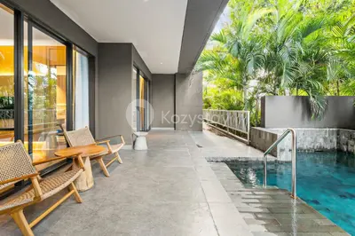 a house with a swimming pool and a table and chairs at Moriya by Kozystay - Nusa Dua in Nusa Dua