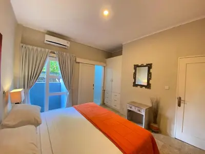 a bedroom with a bed with an orange blanket at 2bedroom Apartment Petitenget Beach in Seminyak