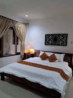a bedroom with a large bed with two pillows at SURFARIS INN on poppies 2 apartment in Legian