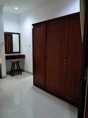 a room with wooden cabinets and a mirror and a stool at SURFARIS INN on poppies 2 apartment in Legian