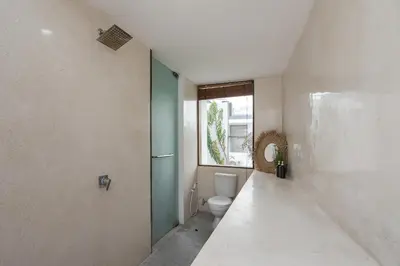 a bathroom with a toilet and a window at Volare villa in Seminyak