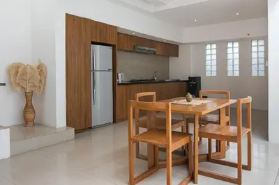 a kitchen with a table and chairs and a refrigerator at Volare villa in Seminyak
