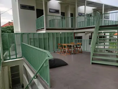a balcony with a table and chairs in a building at HŌM Coliving Bali in Kerobokan