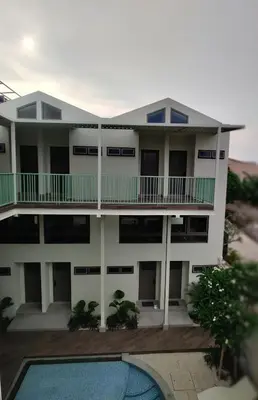 a building with a swimming pool in front of it at HŌM Coliving Bali in Kerobokan