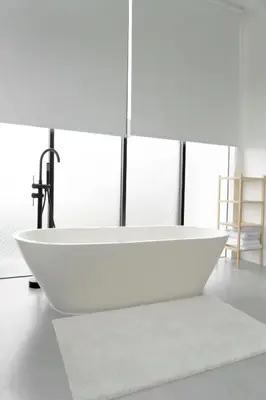 a white bath tub sitting in a room with windows at Casa Luna Villa in Kerobokan