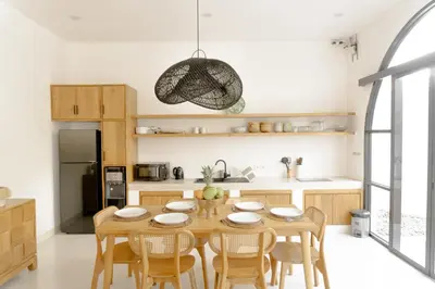 a kitchen with a wooden dining table and chairs at Casa Luna Villa in Kerobokan