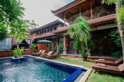 a house with a swimming pool in front of a house at The Saharah Mirage Bali in Kuta