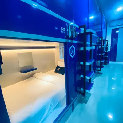 a room with a bed in a room with blue lights at Rosalyne Sleepbox Denpasar Bali in Seminyak