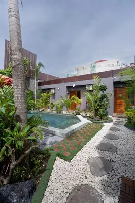a house with a swimming pool in a yard at Griya Sadhana Dewi Sri in Legian