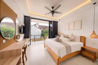 a bedroom with a bed and a desk and a window at Shanti Villa - 3BR Luxury Private Pool Villa in Seminyak in Seminyak
