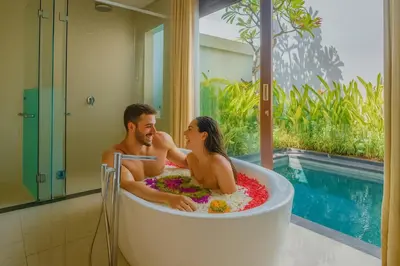 a man and a woman sitting in a bath tub at Anari Villas Kuta by The Wina Resorts in Legian