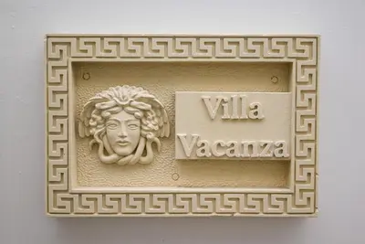 a plaque with a statue of a woman on a wall at The Medusa Villas Bali in Seminyak