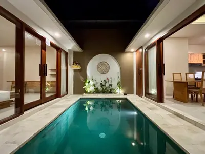 a swimming pool in a house with windows at Solvana Villas Sanur by AGATA in Sanur