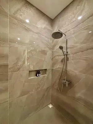 a bathroom with a shower with a shower head at Solvana Villas Sanur by AGATA in Sanur