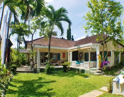 a house with a yard with palm trees at Villa bunny seminyak in Seminyak