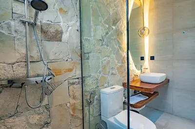 a bathroom with a shower and a toilet and a sink at Casa Samudra - 3BR Villa in Seminyak in Seminyak