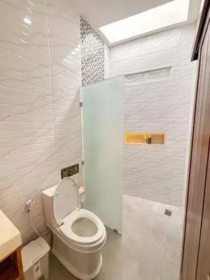 a bathroom with a toilet and a shower at The Abian Villa Seminyak in Seminyak