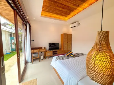 a bedroom with a bed with a vase at The Abian Villa Seminyak in Seminyak