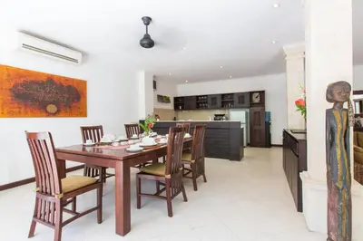 a kitchen and dining room with a wooden table and chairs at Villa Sedap Malam - Private 2 Bedroom Villa Near Seminyak Beach in Kuta