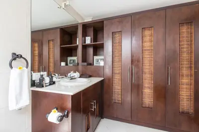 a bathroom with a sink and wooden cabinets at Villa Sedap Malam - Private 2 Bedroom Villa Near Seminyak Beach in Kuta