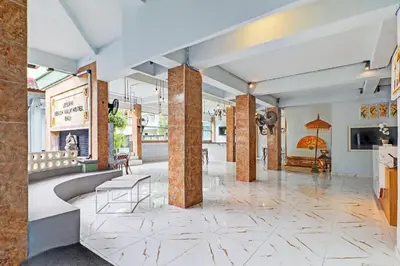 a lobby with marble floors and columns and a lobby with chairs at Townhouse Oak Legian Near Legian Beach Formerly Sayang Maha Merta in Legian