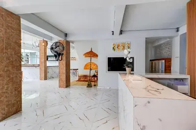 a kitchen with white marble flooring and a tv at Townhouse Oak Legian Near Legian Beach Formerly Sayang Maha Merta in Legian