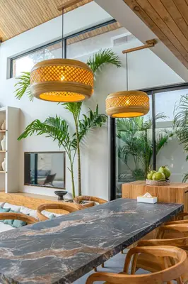 a dining room with a table and chairs and lights at Villa Bayu by GORO in Canggu
