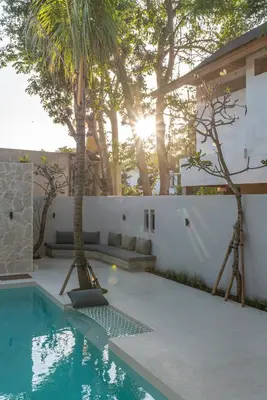 a house with a swimming pool with palm trees at Villa Bayu by GORO in Canggu