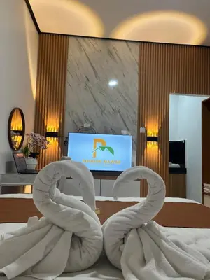 a hotel room with a bed with two white towels at Pondok Mawar in Badung