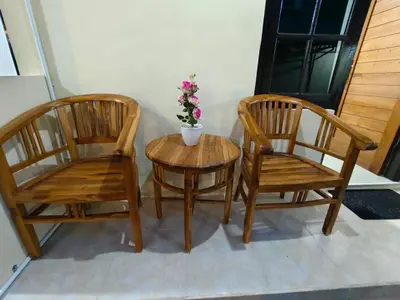two chairs and a table with a potted plant on it at Pondok Mawar in Badung