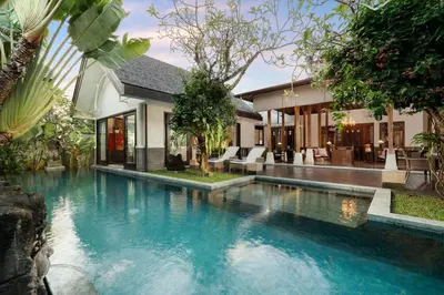 a swimming pool in front of a house at Puri Tibo Tanjung Sanur in Sanur