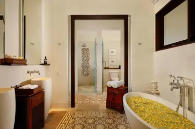 a bathroom with a tub and a walk in shower at Puri Tibo Tanjung Sanur in Sanur