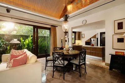 a living room with a table and a kitchen at Puri Tibo Tanjung Sanur in Sanur