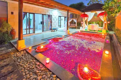 a house with a large pool of red flowers at Private Pool Villas Kuta Bali in Kuta