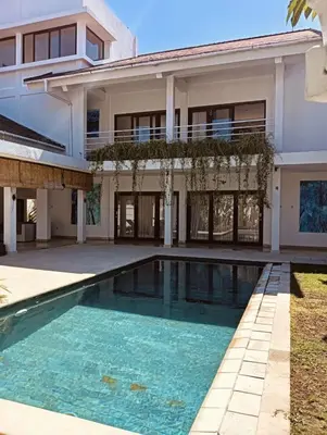 a house with a swimming pool in front of it at Villa Louis Tanjung Benoa in Nusa Dua