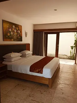 a bedroom with a large bed and a large window at Villa Louis Tanjung Benoa in Nusa Dua