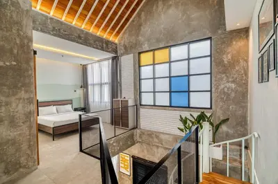 a room with a staircase and a bed in a room at Tuju Apartment 1BR Loft in Umalas in Canggu