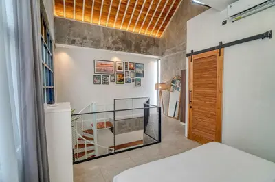 a room with a bed and a staircase in it at Tuju Apartment 1BR Loft in Umalas in Canggu