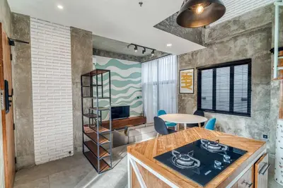 a kitchen with a stove and a table in a room at Tuju Apartment 1BR Loft in Umalas in Canggu
