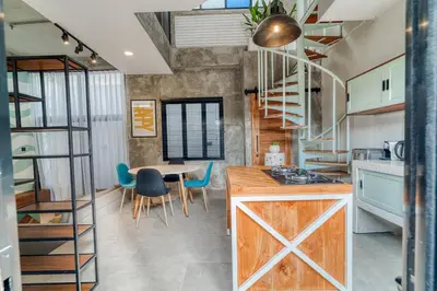 a kitchen and dining room with a table and chairs at Tuju Apartment 1BR Loft in Umalas in Canggu