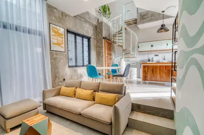 a living room with a couch and a table at Tuju Apartment 1BR Loft in Umalas in Canggu