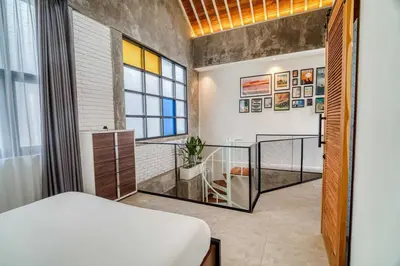 a bedroom with a bed and a desk in a room at Tuju Apartment 1BR Loft in Umalas in Canggu