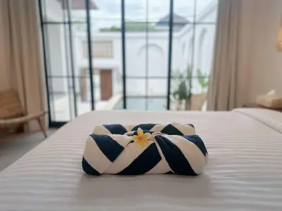 a towel on a bed with a flower on it at Kamila Villas 2BR Private Pool Seminyak Central in Seminyak