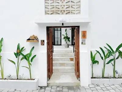 a staircase leading to a white house with plants at Kamila Villas 2BR Private Pool Seminyak Central in Seminyak