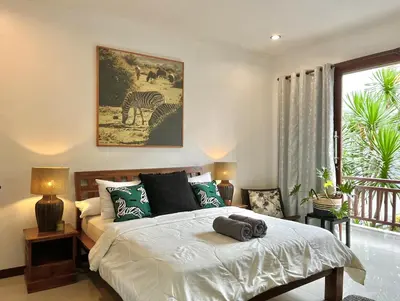 a bedroom with a bed and a picture of a zebra at Modern Guesthouse in Seminyak in Seminyak
