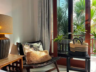 a room with a chair and a lamp and a window at Modern Guesthouse in Seminyak in Seminyak