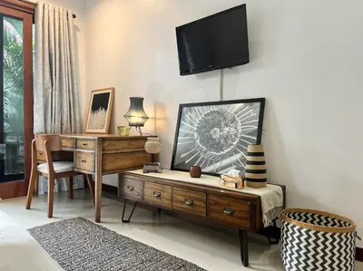 a bedroom with a desk and a tv on a wall at Modern Guesthouse in Seminyak in Seminyak