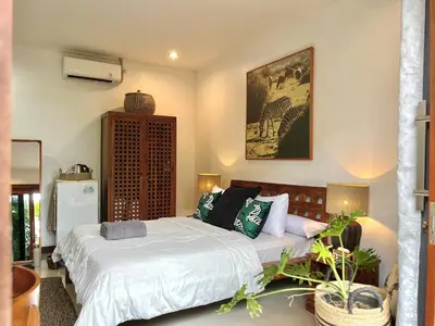 a bedroom with a bed and a couch at Modern Guesthouse in Seminyak in Seminyak