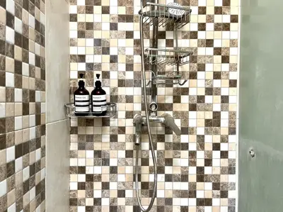 a bathroom with a shower with a checkered wall at Modern Guesthouse in Seminyak in Seminyak