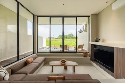a living room with a couch and a fireplace at Villa Mesra Stunning Paddy Fields Views - Canggu Berawa in Canggu